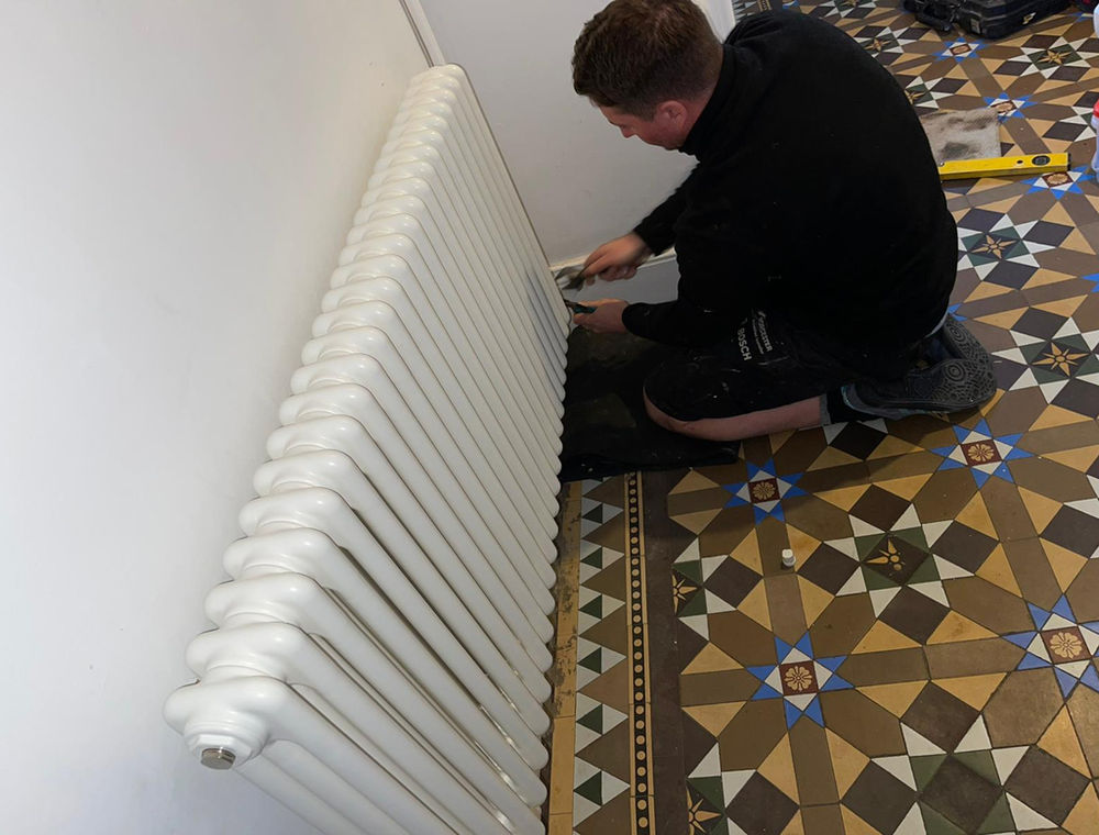 Heating engineer installing a radiator
